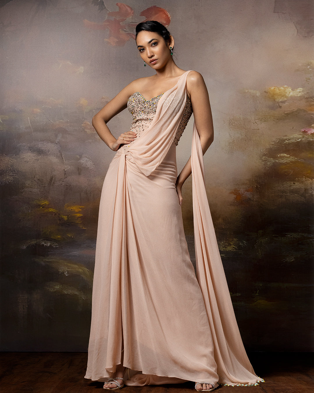 Featuring a beige corset saree gown in gorgette, crepe and net with embroidery on the corset and danglings at the pallu.