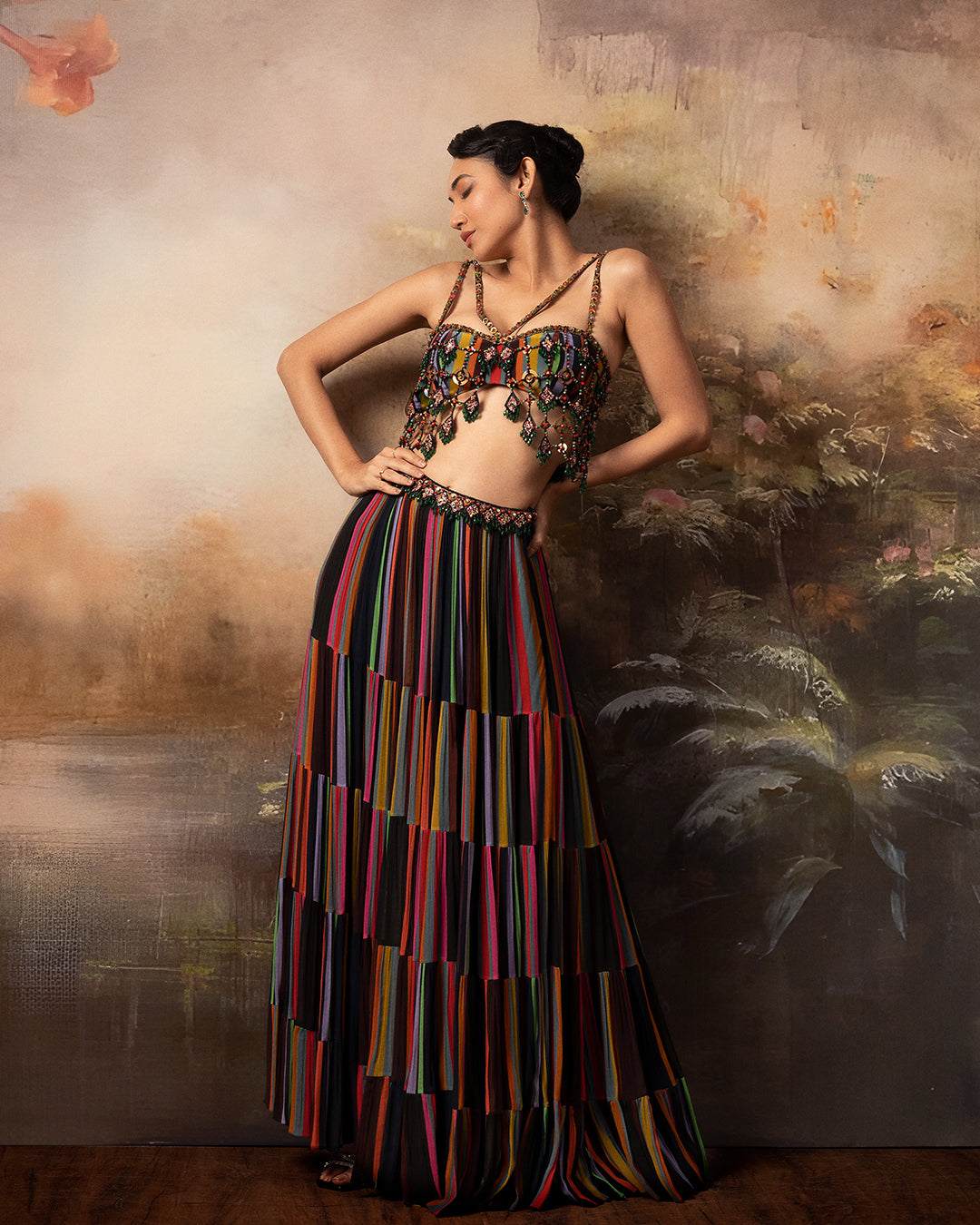 Featuring a flowy lehenga with assymetrical skirt in gorgette and crepe with mesh embroidery on top