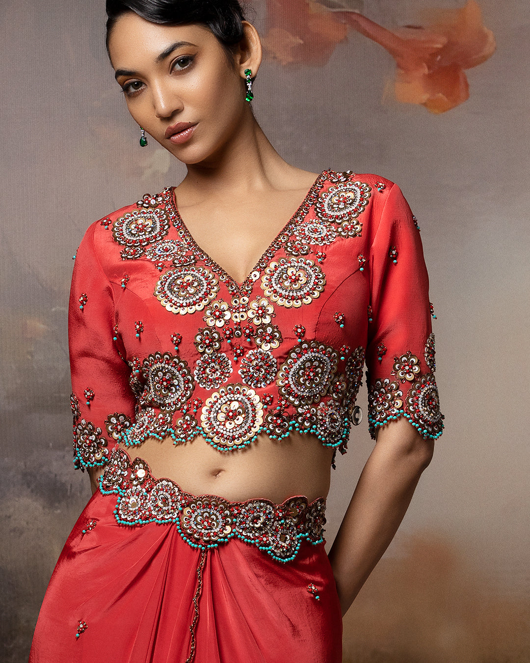 Featuring a short cropped blouse with draped skirt with embroidery in crepe