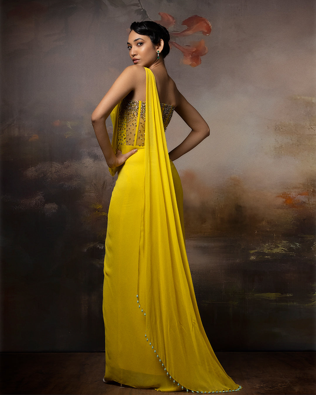 Featuring a citrin corset saree gown in gorgette, crepe and net with embroidery on the corset and danglings at the pallu.